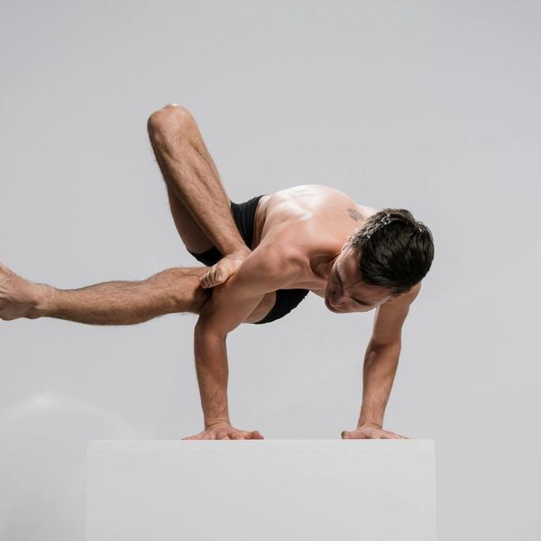 A man focused on a balance and strength exercise, showing full body control.