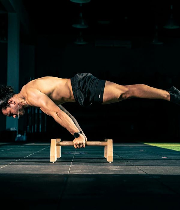 Man performing a controlled strength exercise in a modern, minimalist gym.
